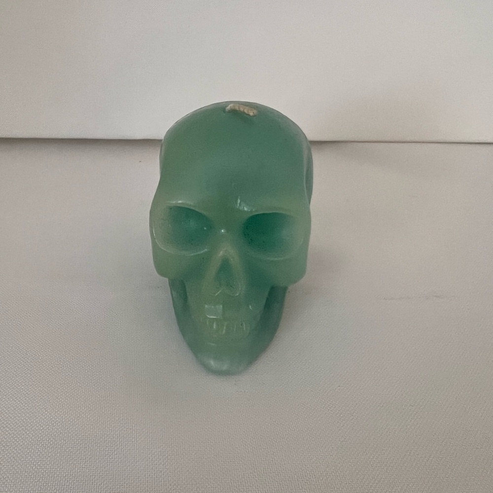 Green skull candle with a small white mark on the top #skull